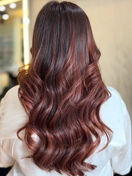 A back view of the rich auburn hair, styled in soft waves to showcase the beautiful red and brown tones.
