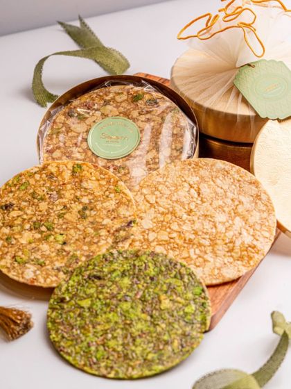 Enjoy the crunch of my Healthy Chikkis. This platter shows different varieties, including a vibrant green pistachio chikki, all made with natural jaggery and packed with flavour.