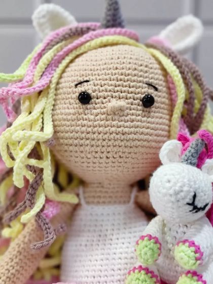 A close-up on the face of my unicorn doll and her tiny companion. I pay special attention to the embroidered features to give each doll a unique and gentle expression.