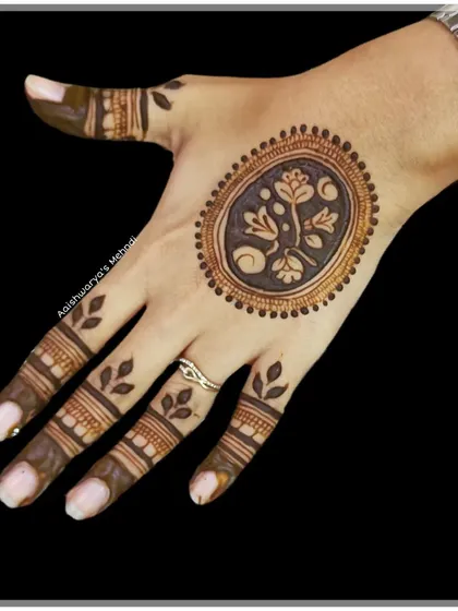 A minimalist design featuring a single floral motif in an oval frame on the back of the hand. This is perfect for someone who wants a small but beautiful touch of henna.