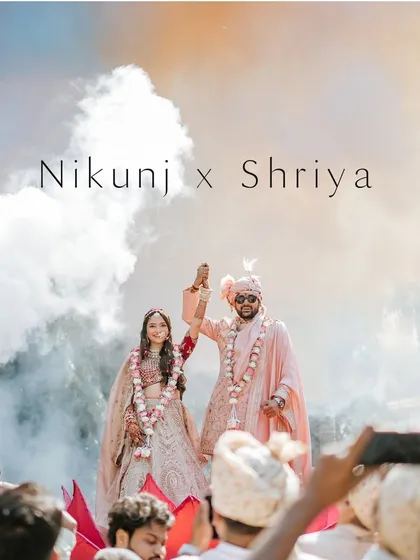 A grand jaimala moment with smoke effects adding to the drama and celebration. This shot captures the peak excitement of the ceremony, a true "wow" moment for the couple.