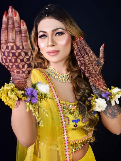 Showcasing the intricate henna design. The makeup is kept glamorous yet elegant to match the festive vibe.