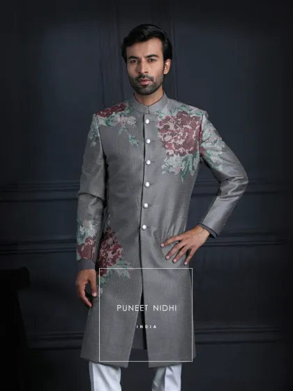 An Achkan of contrasts. A deep charcoal grey base is embroidered with blooming vintage roses, redefining classic tailoring with floral finesse.