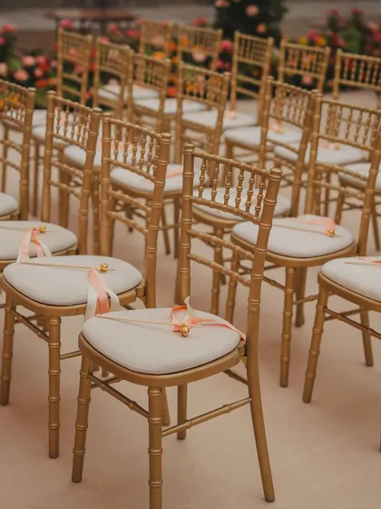 Gold chiavari chairs with custom sashes, ready for the ceremony. Even the seating is an opportunity to add a touch of elegance and personalization.