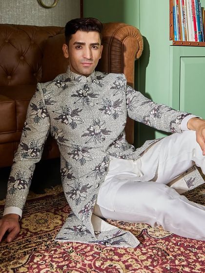 This shot captures the relaxed yet fashionable vibe of the floral jacket. Paired with simple white trousers, the jacket remains the undeniable hero of the outfit.