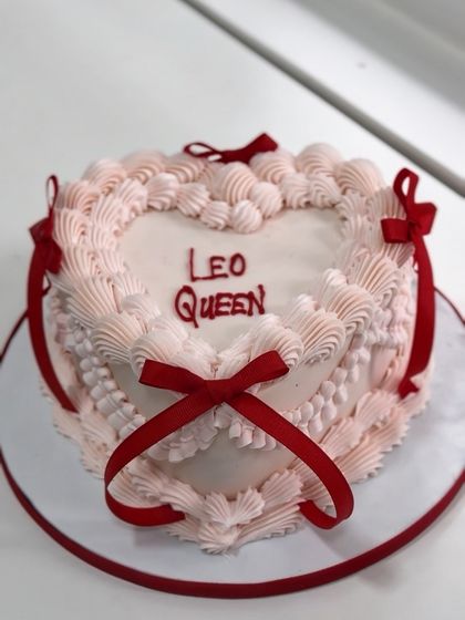 Born to rule, baked to slay. This "Leo Queen" heart-shaped cake is a statement of confidence, featuring vintage piping and bold red ribbons for a queen who wears her crown with class.