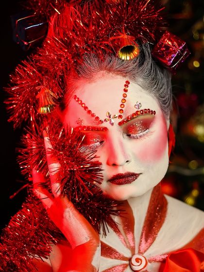 A close-up on the intricate details of the Christmas look, including the gem-studded eyebrows and glittery eyeshadow.
