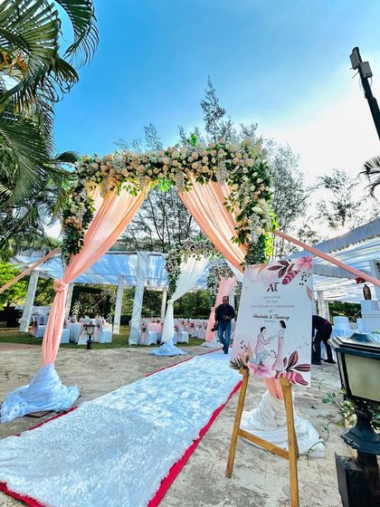 The entrance to the wedding aisle, marked by a floral arch and a personalized welcome sign, setting a romantic tone for the ceremony.
