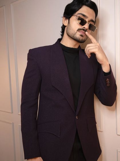 This wine-colored tuxedo jacket, paired with a simple black shirt, creates a look of effortless cool. It's about making a statement without being loud.