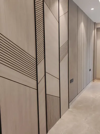 The project nearing completion. This image shows the installation of a custom wall panel with geometric grooves, a design element that adds texture and character before the final furnishings are brought in.