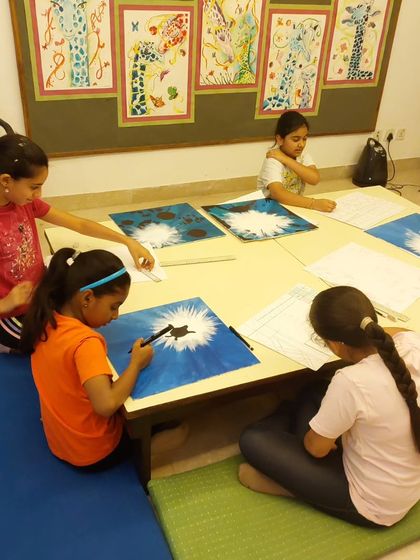 Even our seating is flexible to encourage comfort and focus. These students are working on the floor, deeply engaged in creating their unique abstract paintings.