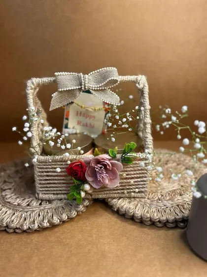 A rustic and charming Rakhi gift basket. This small jute basket is simply decorated with flowers and a bow, perfect for a small, heartfelt gift.