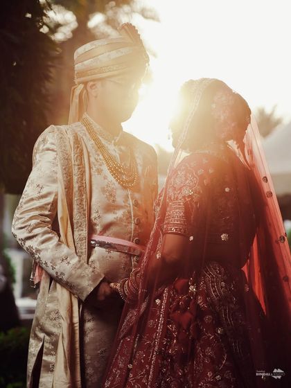 A classic silhouette shot of the couple against the setting sun. This artistic photo uses backlighting to create a romantic and timeless image.