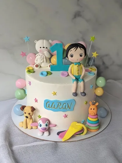 A first birthday cake decorated with all of the baby's favorite toys. I love creating these personalized cakes that are so meaningful to the family.