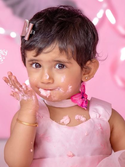 A close-up of the birthday girl enjoying her cake, with a sweet, frosting-covered smile.