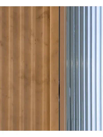 A study in texture and reflection. Fluted surfaces in wood and glass create a rhythmic play of light and shadow, demonstrating how even the smallest details contribute to the overall story of a space.