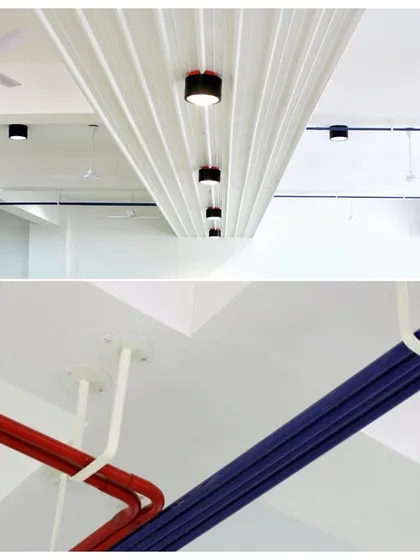 This was a fun project for Ananya Technologies. We took inspiration from a circuit board, using color-coded red and blue pipes as electrical conduits that run across the ceiling, saving costs and creating a unique industrial aesthetic.