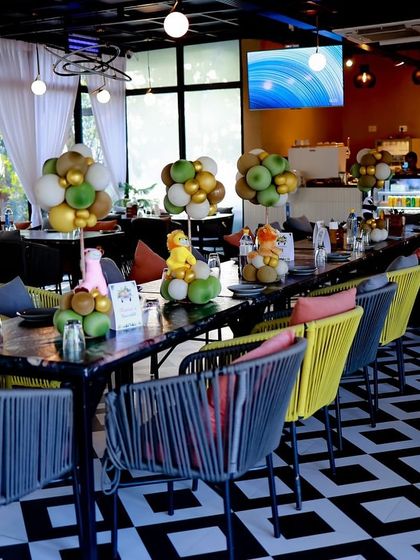 A view of the restaurant space transformed for the "Two Wild" birthday party. Themed centerpieces and balloon arrangements were placed on each table to carry the jungle theme throughout the venue.