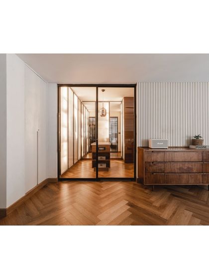 A view into the walk-in closet from the bedroom, showing the seamless transition and the warm, inviting light from within.