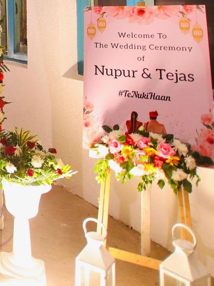 A personalized welcome sign is a must. For this wedding, I placed a custom easel with the couple's hashtag at the entrance, adorned with fresh flowers.