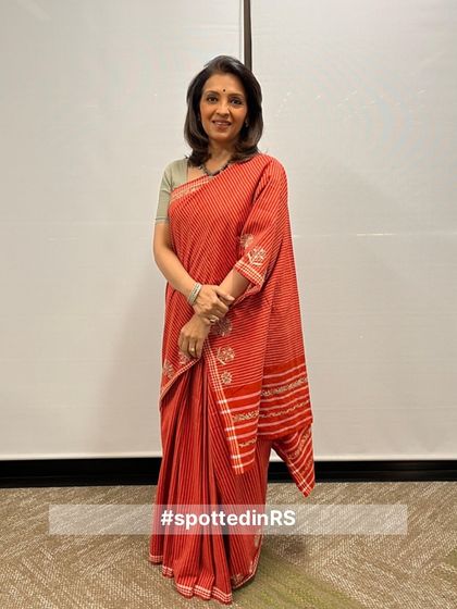A customer in our red striped hand-embroidered saree. This look is a perfect example of how our sarees can be styled for a sophisticated, professional setting.