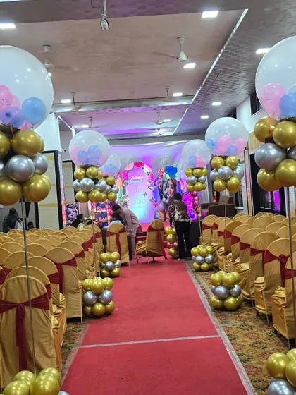 An elegant and premium decoration for a baby shower. We lined the aisle with beautiful balloon stands in gold, silver, and pastel colors, leading up to the main stage and creating a grand entrance for the parents-to-be.