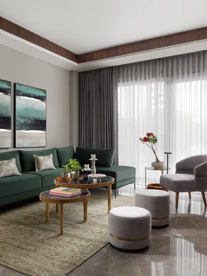 A wider view of the green sofa lounge, showing its relationship to the large window and sheer curtains that diffuse the natural light beautifully.
