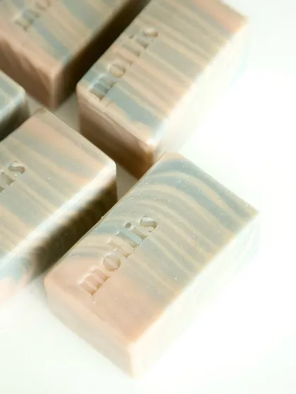 A close-up of the Sweet Orange & Patchouli bars, colored naturally with clays and indigo.
