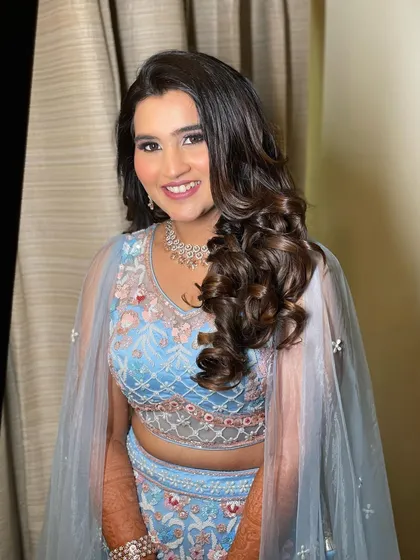 A portrait of the Sangeet client, her hair styled in classic, glamorous waves.