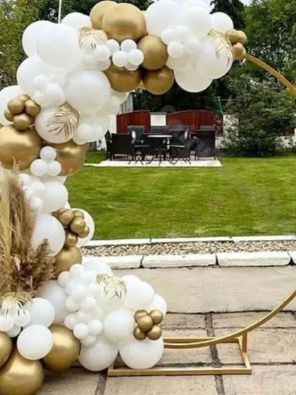 An elegant outdoor balloon hoop in white and gold. This setup is perfect for a garden party, anniversary, or daytime wedding celebration, accented with pampas grass.