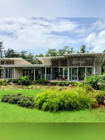 The landscape design includes a mix of manicured lawn and more natural, meadow-like plantings. This variety adds ecological value and visual interest to the property.