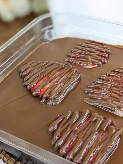 The top view of our Boozy Nutella Strawberry tub, featuring sliced strawberries elegantly drizzled with more Nutella. It’s a preview of the delicious layers that lie beneath.