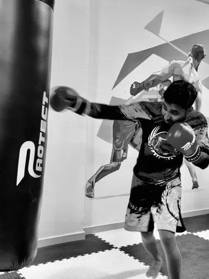 A student throwing a powerful right cross on the heavy bag. This black and white shot captures the focus and intensity we bring to every striking session.