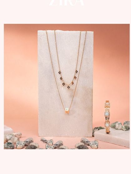 A layered chain set from our Zira collection, featuring a charm neckline and a chic square pendant.