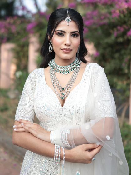 A confident pose in the white lehenga, with arms crossed to showcase the matching diamond bracelets.