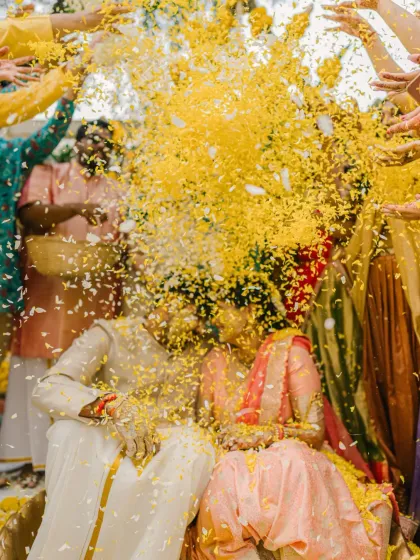 An explosion of yellow petals completely envelops the couple, creating an abstract and beautiful image of celebration.