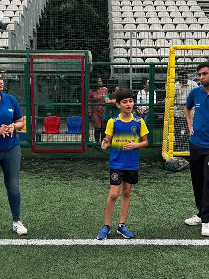 A young player confidently speaks during a sports psychology session, with experts listening on. We encourage our players to be vocal and engaged in their own mental development.