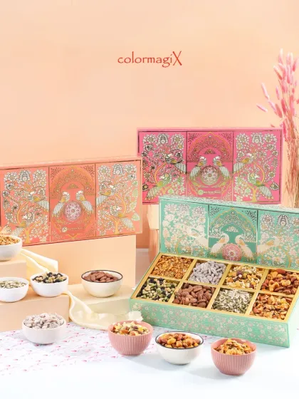 A beautiful display of our peacock-themed festive boxes in pastel orange and green. The boxes open to reveal a variety of dry fruits and sweets, perfect for any celebration.