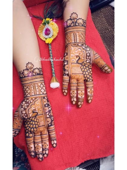 This shot includes a lumba rakhi, showing how the mehendi provides a beautiful backdrop for wedding jewelry and accessories. The peacock design is a classic choice.