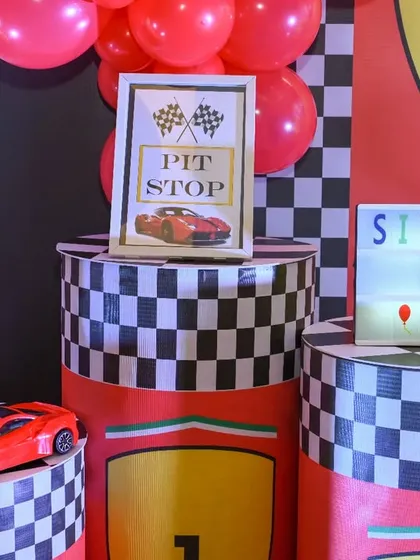 The little details make the theme. A 'Pit Stop' sign, a light-up letter 'S', and a toy Ferrari add to the authentic feel of the race car party.