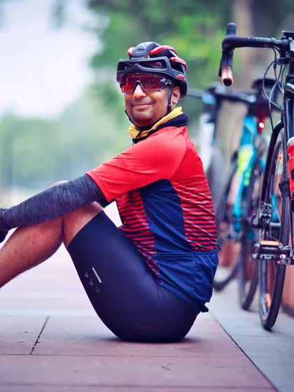 A member taking a break, sitting on the pavement with his bike. These quiet moments of reflection are part of the journey.
