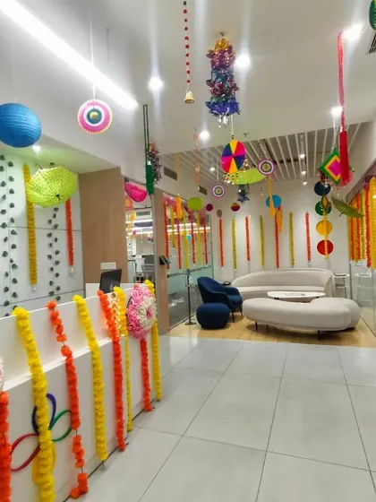 We transform everyday office spaces for festive occasions. Here, a corporate reception area is decorated for Diwali using traditional marigold garlands, colorful paper lanterns, and hanging crafts to create a warm and celebratory atmosphere for employees and visitors.