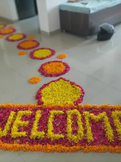A vibrant flower petal pathway to welcome the baby home. The entrance features a 'WELCOME' message made from yellow and pink flowers.