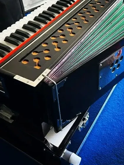 This dark brown folding harmonium is ready for delivery. It features a coupler and a bass-male reed setup, making it a versatile and portable choice for traveling musicians.
