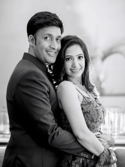 A classic black and white portrait of an engaged couple. The timeless quality of monochrome photography highlights their happy expressions and elegant attire.
