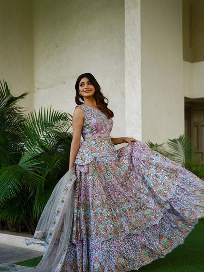 The ivory peplum lehenga in motion, showcasing its beautiful, flowing skirt and unique silhouette. The multi-colored embroidery adds a playful and vibrant touch.