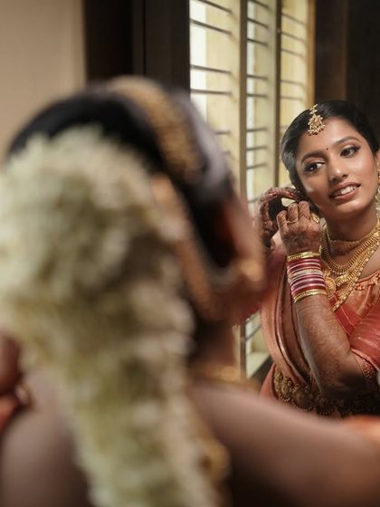 A final touch-up in the mirror. I pay close attention to every detail, from the placement of the bindi to the final setting spray, to ensure a perfect and long-lasting finish.