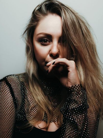 A close-up portrait used for the "Voices of Angels" press release. The sparkly mesh top and direct gaze create a look that is both glamorous and intense.