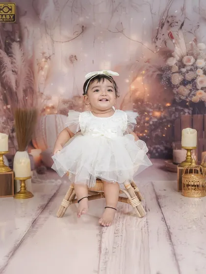 Sitting pretty in her chair, this little angel is surrounded by a dreamy, rustic backdrop with soft lights.