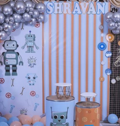 For the little one who loves technology, we designed this fun robot-themed birthday party. The decor features robot graphics, a gear-inspired color palette of orange and blue, and themed cake stands.